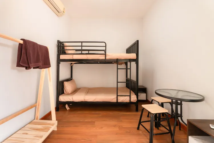 เตียงในห้องพักรวมพร้อมห้องน้ำร่วม