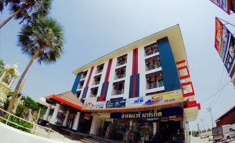 a large building with a red and blue color scheme , situated in front of palm trees at Thanarom Place