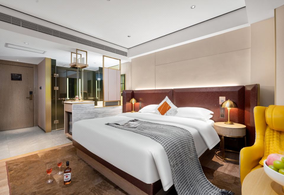 The middle room features a spacious bed, an attached bathroom, and a sitting area adjacent to it at Yishang PLUS（Guangzhou Beijing Road Pedestrian Street）