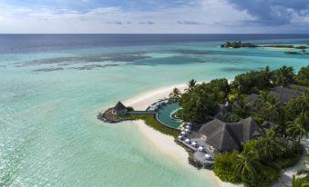 aerial view of a tropical island with a beach and a resort , surrounded by clear blue water at Four Seasons Resort Maldives at Kuda Huraa
