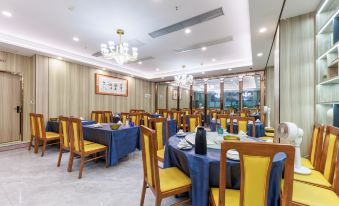 The restaurant is prepared with tables and chairs arranged in the dining rooms, complete with tablecloths at DCC Hotel (Guangzhou Tianhe Coach Terminal Station)