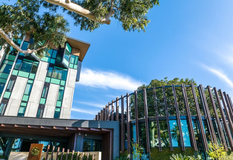 a modern building with a unique design , surrounded by trees and a clear blue sky at Marion Hotel