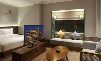 The room is furnished with large windows, a wall-mounted TV, and a bed in front at UrCove by HYATT Hangzhou Westlake