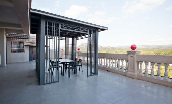 a patio with a metal structure , surrounded by chairs and tables , overlooking a cityscape under a clear blue sky at Diamond Hotel (Liancheng Guanzhishan Airport)