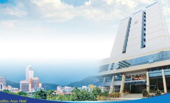 a modern building with a blue roof , surrounded by trees and mountains in the background at Asian Hotel