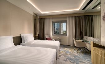 There is a bedroom with two beds and a large window on the far side at Kempinski Hotel Beijing Yansha Center