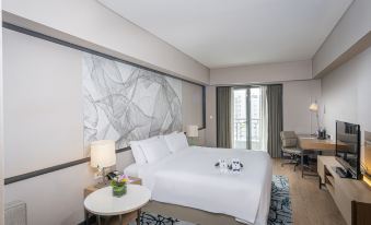The elegant hotel features a bedroom with large windows, a white bed, and a table in the middle at Riverdale Residence Xintiandi Shanghai