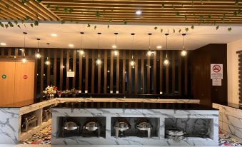 a modern restaurant with a long marble bar , black walls , and hanging lights , creating a unique atmosphere at D Arc Hotel