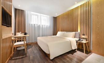 The modern bedroom features a double bed and a large wooden table in the center at X Hotel Taikoo Riaduo, Sanlitun, Beijing