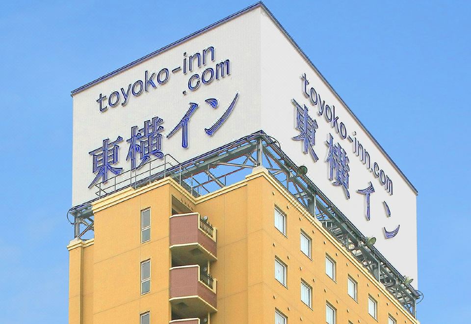 "a large building with a sign that reads "" toyoko - inn "" prominently displayed on the side of the building" at Toyoko Inn Aizuwakamatsu Ekimae