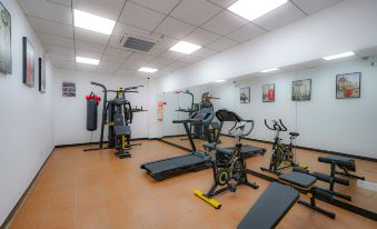 There is a spacious room with multiple exercise equipment, including an indoor weight machine positioned in the center at Baiyun City Hotel (Guangzhou Railway Station Subway Branch)