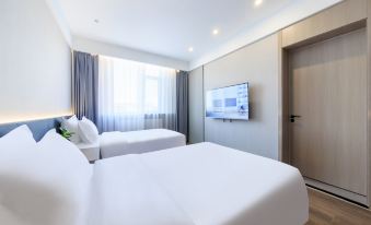 The modern bedroom features double beds and a large window with a view of the middle at Capital Airport International Hotel