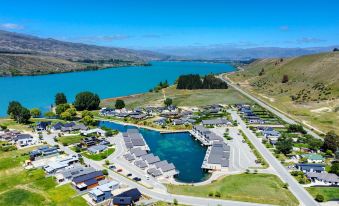 aerial view of a residential area near a lake , featuring multiple houses and a body of water at Marsden Lake Resort Central Otago