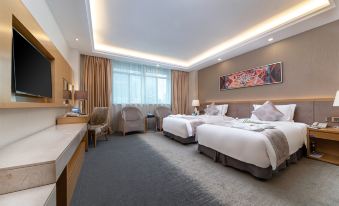 The bedroom features two beds and a large window that overlooks the front yard, providing a comfortable space for sitting at Gems Cube International Hotel