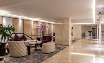 a modern , well - lit lobby with marble flooring and large windows , featuring comfortable seating arrangements and a flower arrangement at Louis Kienne Hotel Simpang Lima
