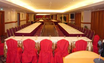 A room is set up with long tables and chairs for an event or function at Golden Crown China Hotel