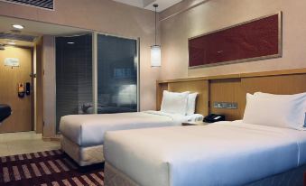 The bedroom features two beds and a spacious glass-walled shower stall in the center at Park Inn by Radisson Shanghai Downtown