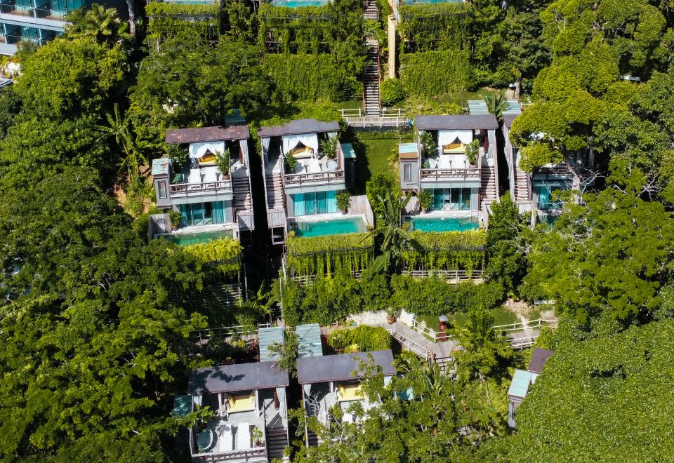 An aerial view shows a resort with a pool and trees surrounding it at Dinso Resort & Villas Phuket, Vignette Collection