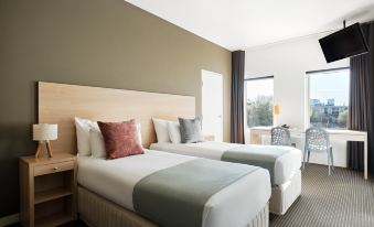 a hotel room with two beds , one on the left and one on the right side of the room at Saint Kilda Beach Hotel, an EVT hotel - Formerly Rydges St Kilda