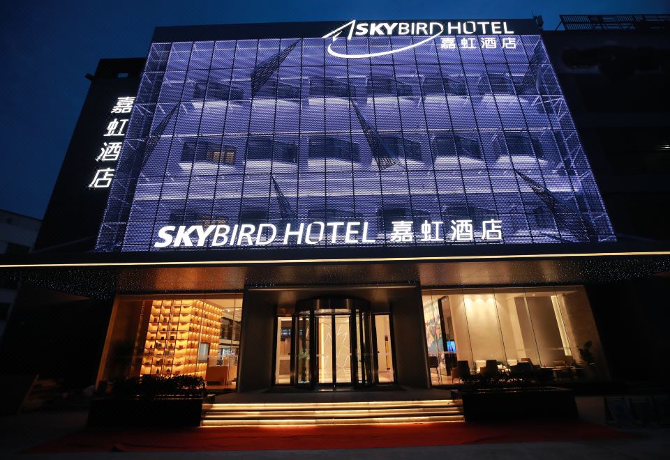 At night, the front entrance of a hotel displays a sign in Chinese and Japanese at Sky Bird Hotel (Shanghai Hongqiao Airport)