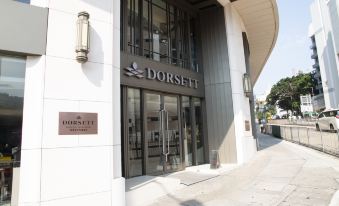 "a large white building with the name "" dorsett "" displayed on its front door , surrounded by trees and other buildings" at Dorsett Wanchai