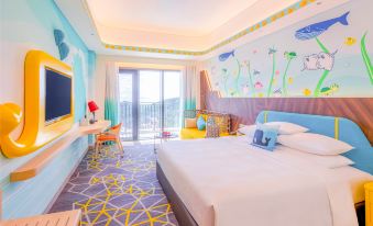 The modern-style room features a double bed and a large window with a view of the pool area at Chimelong Spaceship Hotel