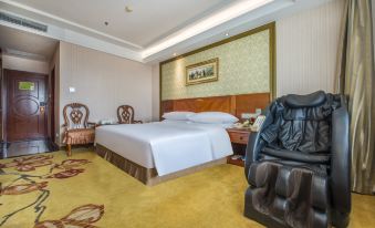 a large bed with white linens is in a room with wooden furniture and a colorful carpet at Vienna Hotel