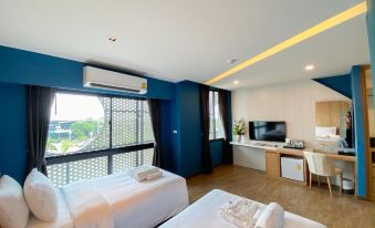 a modern hotel room with blue walls , white bedding , and a balcony view , as well as an air conditioner on the ceiling at Hotel Fuse Rayong