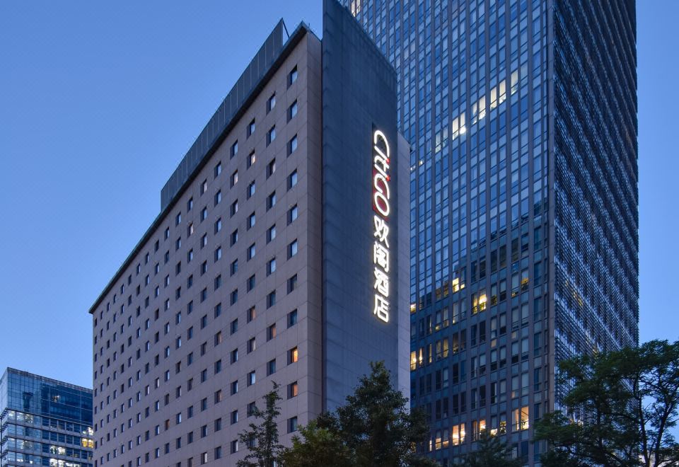 "In front of an office block at night, there is a large building with the word ""hotel"" on it" at CitiGO Hotel Sanyuanqiao Beijing