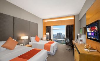 The bedroom features double beds, large windows, and a city view at Jianguo Hotel, Guangzhou