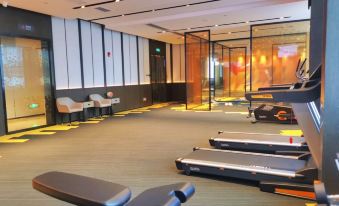 There is a spacious room containing multiple exercise equipment and an indoor yoga mat placed on the floor at Hampton by Hilton Shenzhen North Station