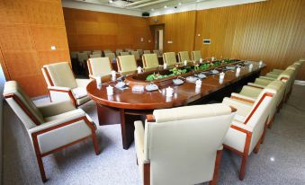 a large conference room with a wooden table surrounded by chairs and various settings such as windows and doors at Airport Hotel