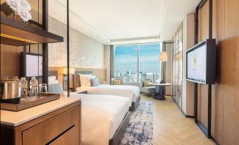 The bedroom at the far end has two beds and large windows, following an open concept design at Eastin Grand Hotel Phayathai