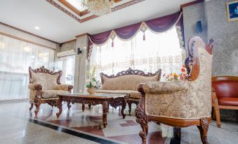a luxurious living room with ornate furniture , including a couch , chairs , and a coffee table at Chaipat Hotel