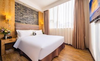 The main bedroom area has a double bed and a large window for guests at Howdy Smart Hotel (Chengdu Chunxi Taikoo Li)