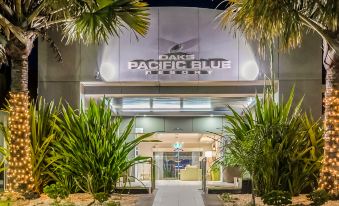 "a nighttime scene of a hotel entrance with palm trees and a sign that reads "" papà blue palermo .""." at Oaks Port Stephens Pacific Blue Resort