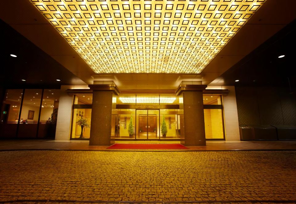 a large , illuminated hotel entrance with a mosaic ceiling and red carpet leading to the entrance at Keio Plaza Hotel Hachioji
