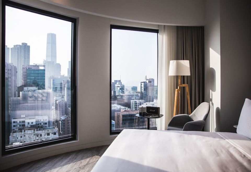 A bedroom on an upper floor with large windows and a balcony offers a city view at Page148, Page Hotels