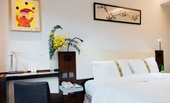 The room is furnished with a bed, table, and two lamps on each side, accompanied by framed pictures at Empire Hotel Hong Kong - Causeway Bay