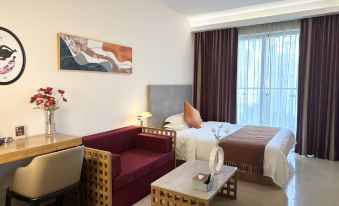The room features a double bed, a table, and chairs in the living area adjacent to a spacious sliding door at Timmy Apartment Hotel