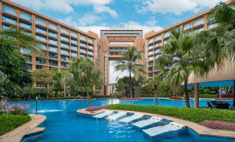 a large resort with a swimming pool surrounded by palm trees and a large building at Royal Garden Hotel