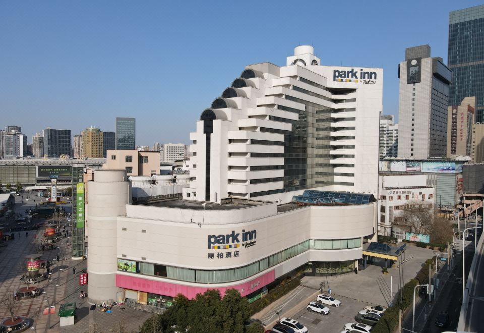 A centrally located large building surrounded by other buildings, visible from above at Park Inn by Radisson Shanghai Downtown