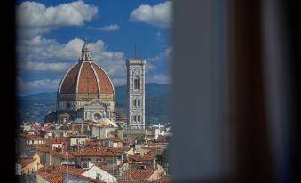 a view of the florence cathedral and other buildings with mountains in the background , from a high vantage point at Grand Hotel Adriatico