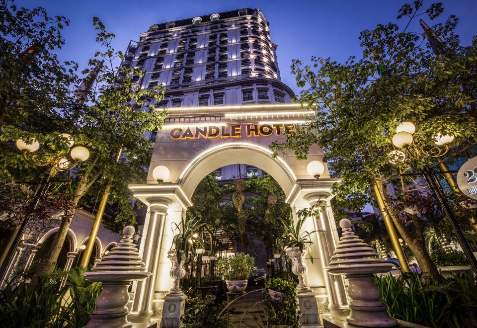 "a tall hotel with a sign that says "" candle hotel "" is surrounded by trees and lights" at Super Hotel Candle