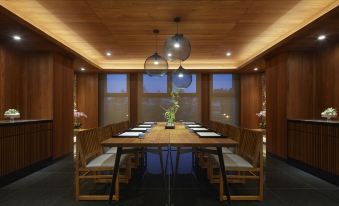 The dining room is spacious and furnished with wooden tables and chairs, illuminated by overhead ceiling lights at The Westin Yilan Resort