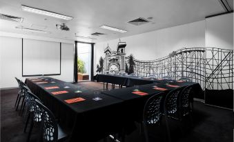 a black table with chairs is set up in a conference room with an amusement park theme at Saint Kilda Beach Hotel, an EVT hotel - Formerly Rydges St Kilda