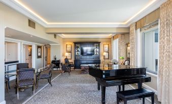 a spacious living room with a grand piano in the center , surrounded by couches and chairs at Stamford Plaza Brisbane