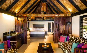 a luxurious bedroom with a king - sized bed , a couch , and a tv . the room is well - decorated and spacious at Matamanoa Island Resort