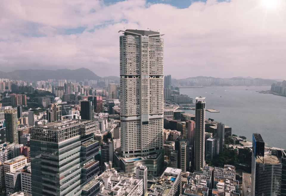 The cityscape features tall buildings and skyscrapers in the foreground, as viewed from a high vantage point at Hyatt Regency Hong Kong, Tsim Sha Tsui