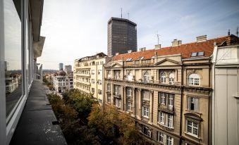 a city skyline with a tall building in the background , surrounded by various buildings and trees at Mark Hotel Belgrade